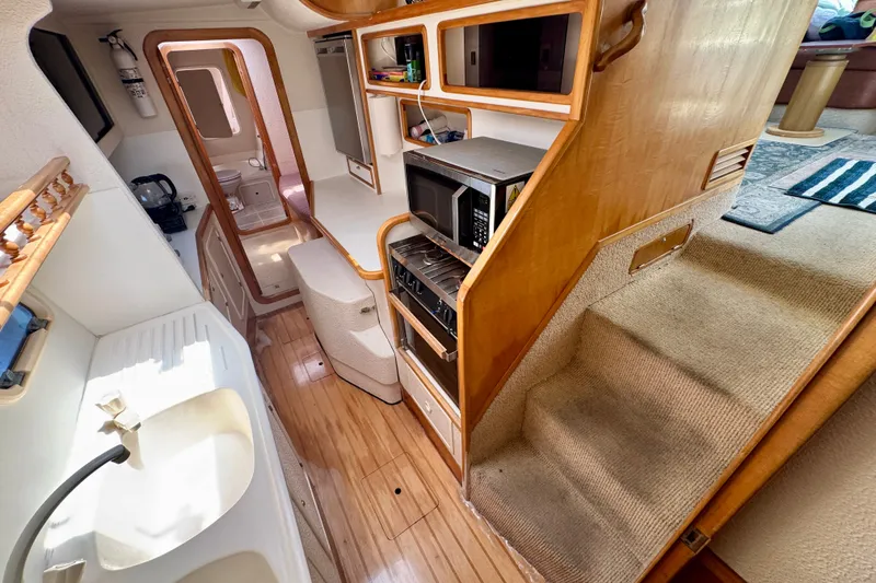Slide: The Image of Interior of 2000 St Francis 44 yacht, featuring kitchen and stairs with wooden accents. - 31