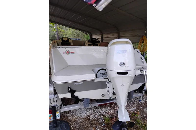 Slide: The Image of 2021 Stingray 172 SC boat with outboard motor, parked under a shelter. - 9