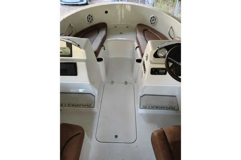 Slide: The Image of 2021 Stingray 172 SC boat interior with brown seating and dual consoles. - 4