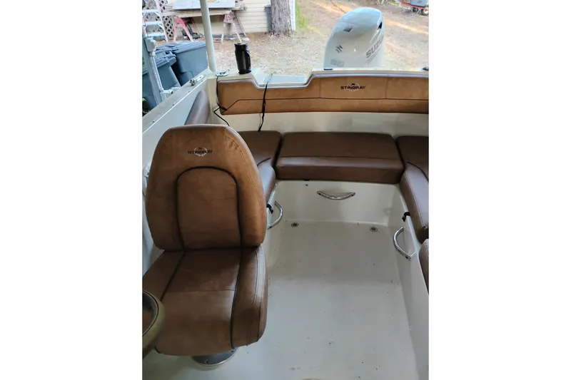 Slide: The Image of 2021 Stingray 172 SC boat interior with brown seating and Suzuki outboard motor. - 13