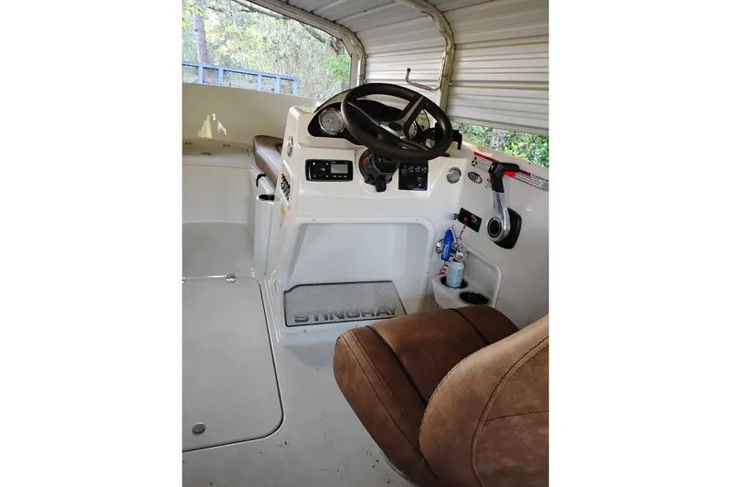 Slide: The Image of Interior of a 2021 Stingray 172 SC boat, featuring steering wheel and controls. - 8