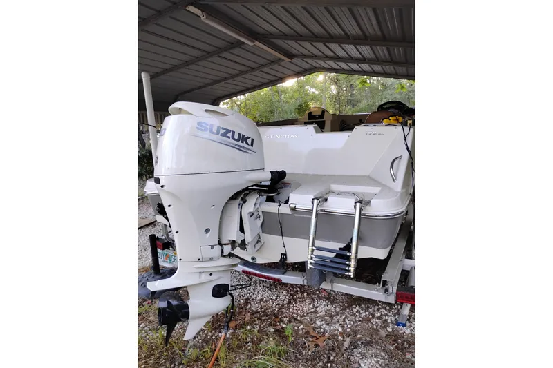 Slide: The Image of 2021 Stingray 172 SC boat with Suzuki outboard motor under a metal canopy. - 16
