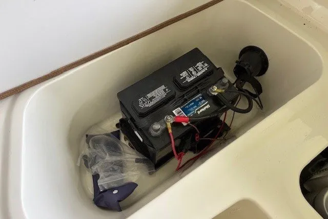 Slide: The Image of A boat battery compartment with a battery and cables inside. - 26