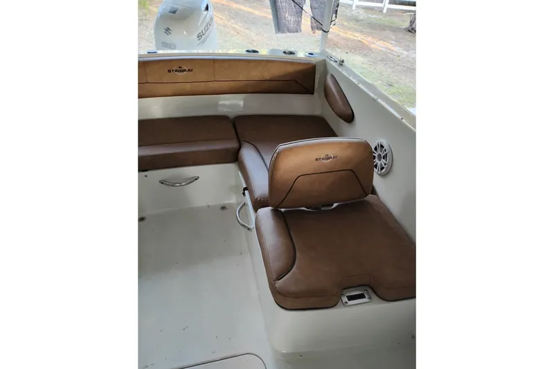 Slide: The Image of 2021 Stingray 172 SC boat interior with brown seating and Suzuki engine in background. - 6