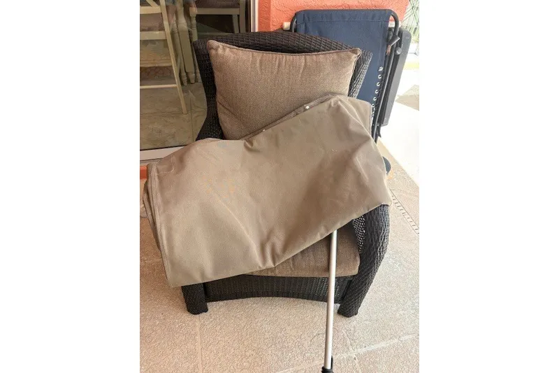 Slide: The Image of Outdoor chair with cushion and folded umbrella on patio. - 28