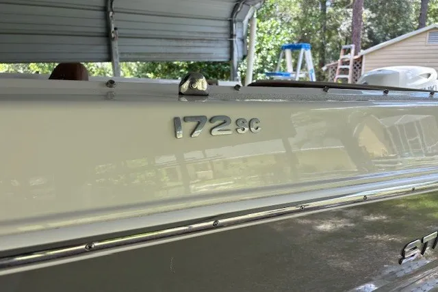 Slide: The Image of 2021 Stingray 172 SC boat under a metal canopy, side view. - 19