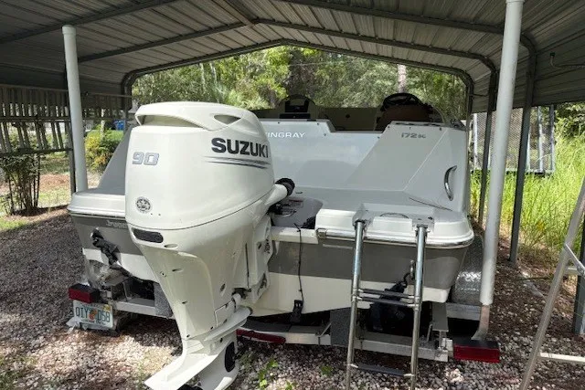 Slide: The Image of 2021 Stingray 172 SC boat with Suzuki 90 outboard motor under a metal shelter. - 20