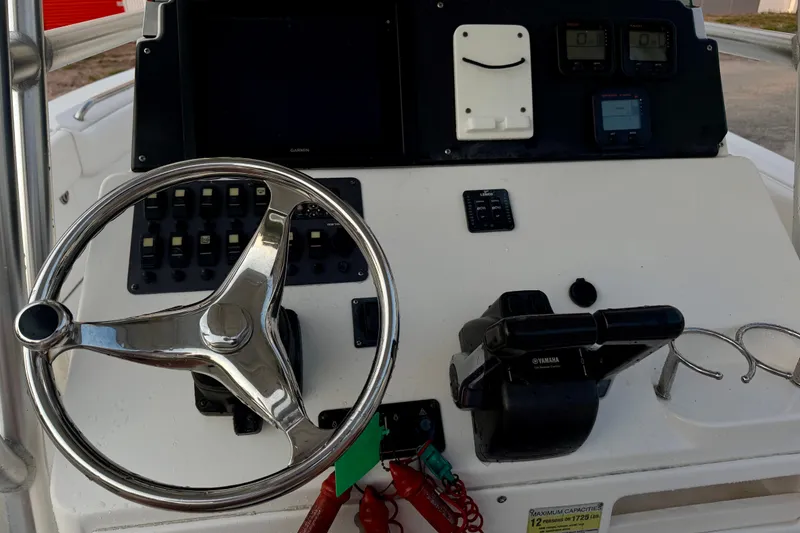 Slide: The Image of Control panel of a 2013 Robalo R260 Center Console boat with steering wheel and gauges. - 23