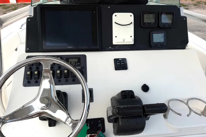 Slide: The Image of 2013 Robalo R260 Center Console boat dashboard with steering wheel and navigation controls. - 20