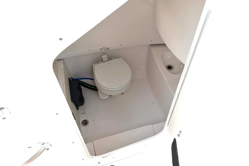 Slide: The Image of Interior view of 2013 Robalo R260 Center Console boat's compact marine toilet area. - 33