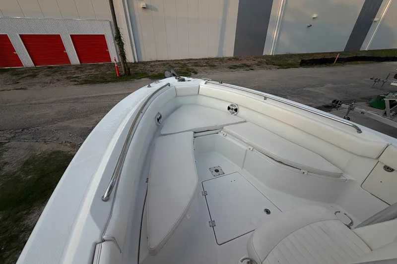 Slide: The Image of 2013 Robalo R260 Center Console boat interior with white seating and storage compartments. - 19