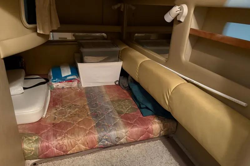 Slide: The Image of Interior cabin of a 1998 Sea Ray 290 Sundancer with storage and bedding. - 22