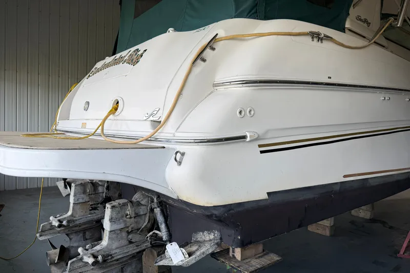 Slide: The Image of 1998 Sea Ray 290 Sundancer boat in storage, showing stern and outdrive details. - 6