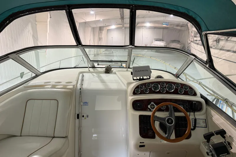 Slide: The Image of 1998 Sea Ray 290 Sundancer cockpit with Garmin navigation, wood steering wheel, and leather seating. - 9