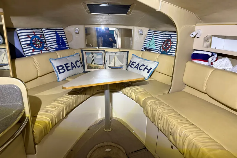 Slide: The Image of 1998 Sea Ray 290 Sundancer cabin with nautical-themed decor and cozy seating area. - 20