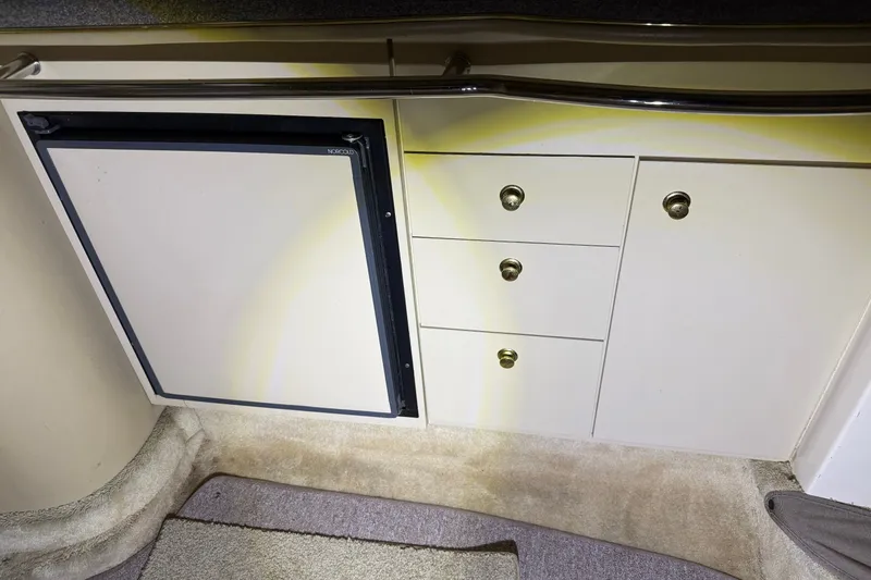 Slide: The Image of Interior view of a 1998 Sea Ray 290 Sundancer, featuring a compact kitchenette with storage. - 18