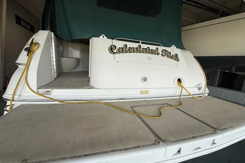Slide: The Image of 1998 Sea Ray 290 Sundancer boat with "Calculated Risk" name, docked indoors. - 5