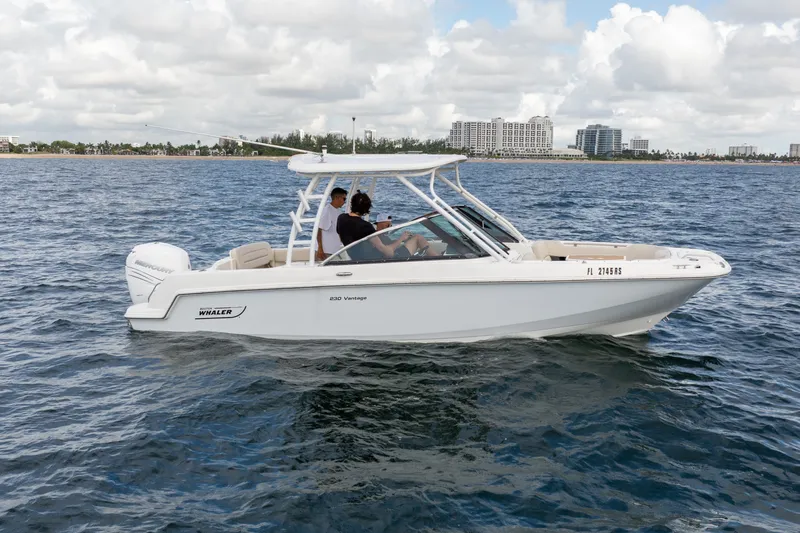 The Image of 2018 Boston Whaler 230 Vantage boat cruising on open water under cloudy skies. - 0