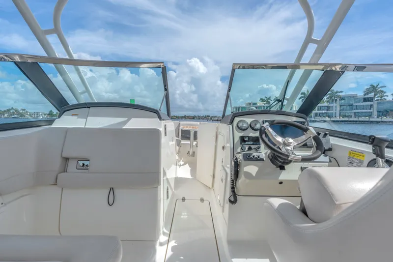 Slide: The Image of 2018 Boston Whaler 230 Vantage boat interior with steering wheel and dashboard, under clear skies. - 20