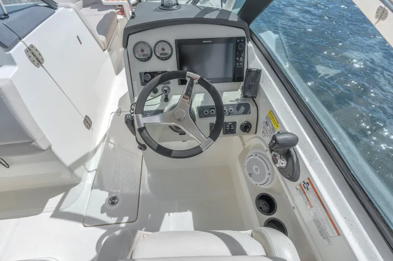 Slide: The Image of 2018 Boston Whaler 230 Vantage helm with steering wheel and navigation controls. - 24
