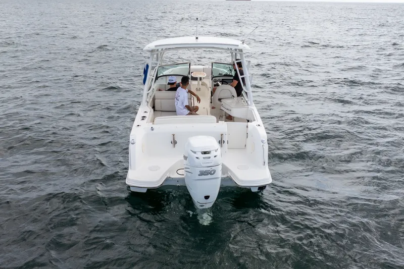 Slide: The Image of 2018 Boston Whaler 230 Vantage boat on open water, rear view with passengers. - 12