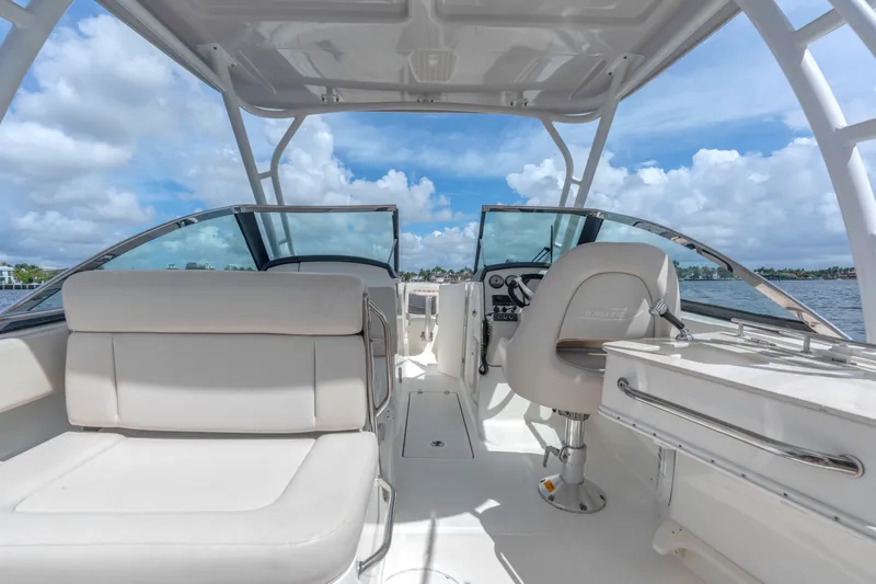 Slide: The Image of 2018 Boston Whaler 230 Vantage boat interior with seating and helm, under a clear sky. - 19