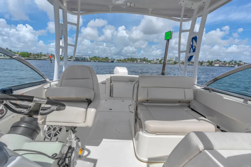 Slide: The Image of 2018 Boston Whaler 230 Vantage boat interior with seating, steering wheel, and ocean view. - 21