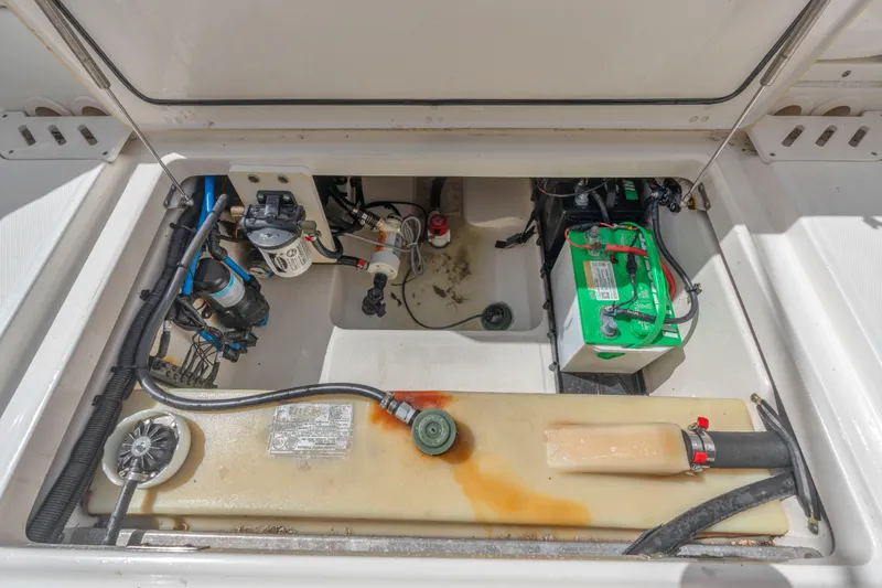 Slide: The Image of 2018 Boston Whaler 230 Vantage engine compartment with battery and fuel system components. - 31
