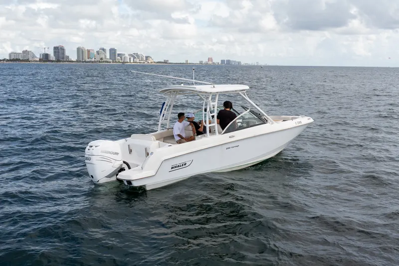 Slide: The Image of 2018 Boston Whaler 230 Vantage boat cruising on open water near city skyline. - 5