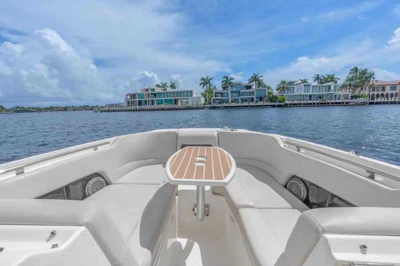 Slide: The Image of 2018 Boston Whaler 230 Vantage boat interior with waterfront view and luxury homes. - 22