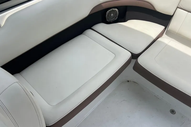 Slide: The Image of Interior seating of a 2012 Cobalt 220 boat, featuring white and brown cushioned seats. - 13