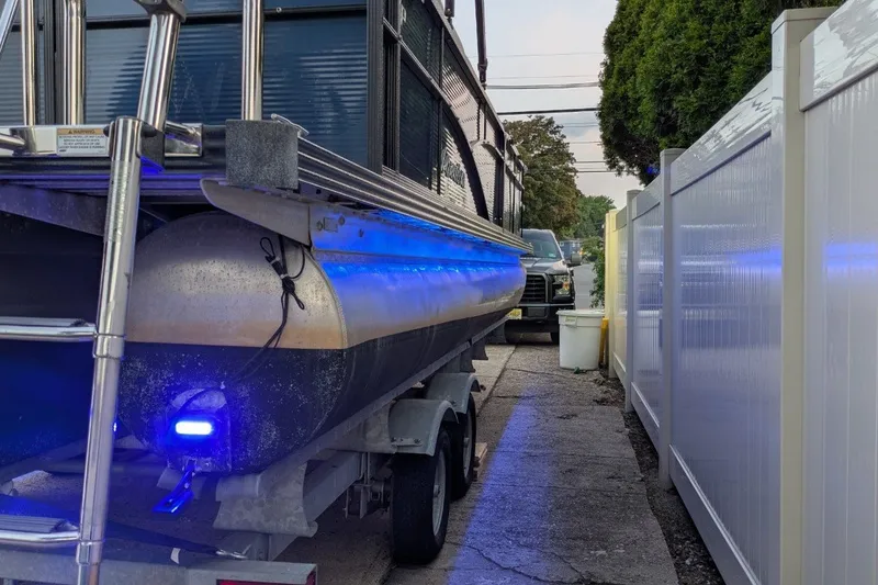 Slide: The Image of 2017 Manitou 23 Aurora VP pontoon boat on trailer with blue LED lights. - 6