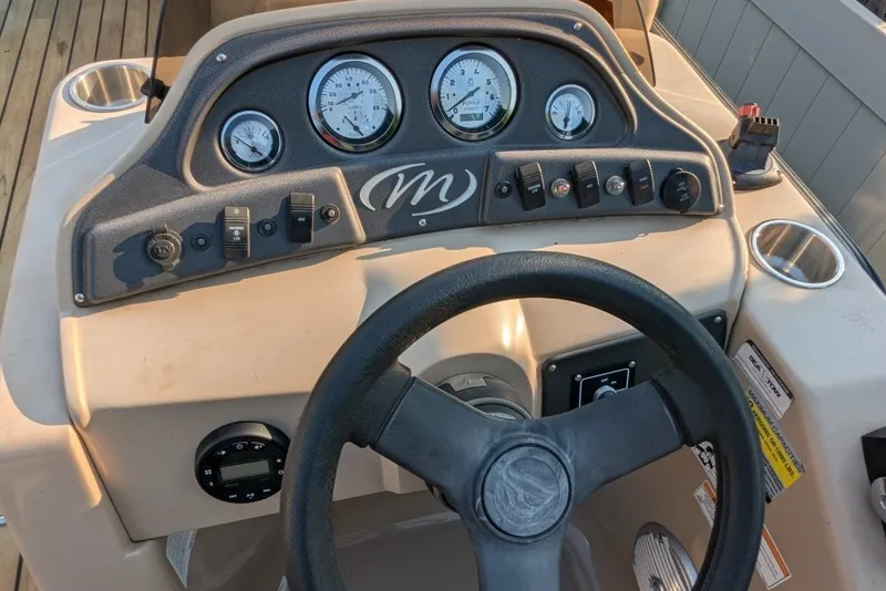 Slide: The Image of Dashboard of a 2017 Manitou 23 Aurora VP boat with gauges and controls. - 16