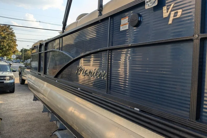 Slide: The Image of 2017 Manitou 23 Aurora VP pontoon boat with sleek blue exterior parked outdoors. - 22