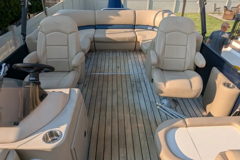 Slide: The Image of Luxurious 2017 Manitou 23 Aurora VP pontoon boat interior with plush seating and wood flooring. - 2
