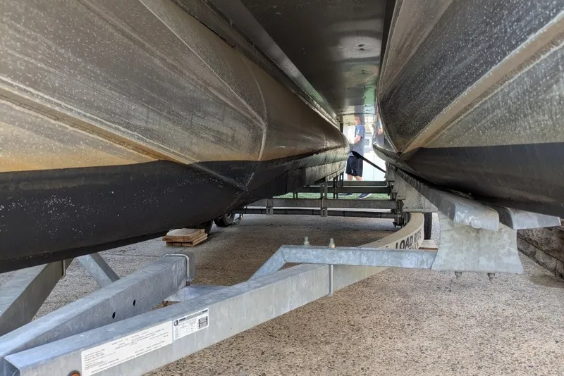 Slide: The Image of Underneath view of a 2017 Manitou 23 Aurora VP pontoon boat on a trailer. - 19