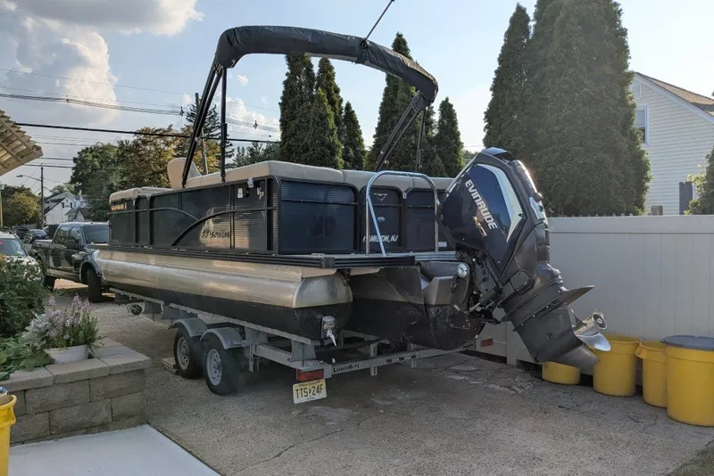 The Image of 2017 Manitou 23 Aurora VP pontoon boat on trailer with Evinrude outboard motor. - 0