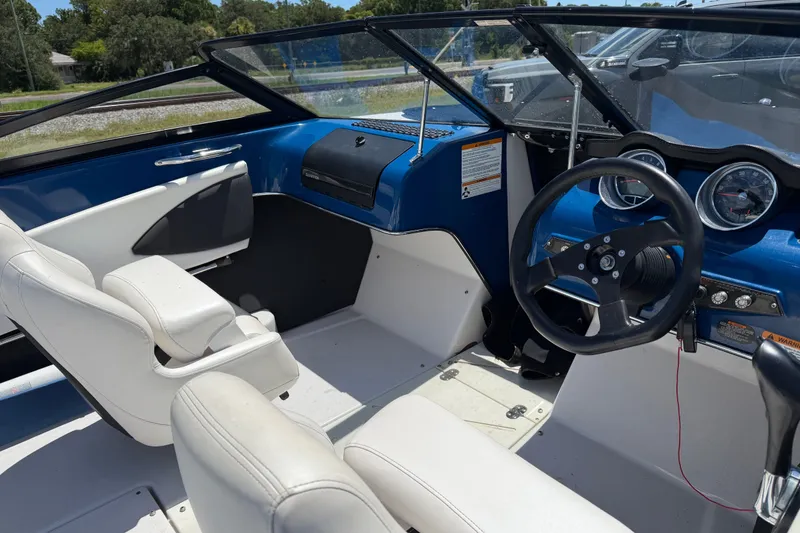 Slide: The Image of 2018 Glastron GTS 187 boat interior with white seats and blue dashboard. - 1
