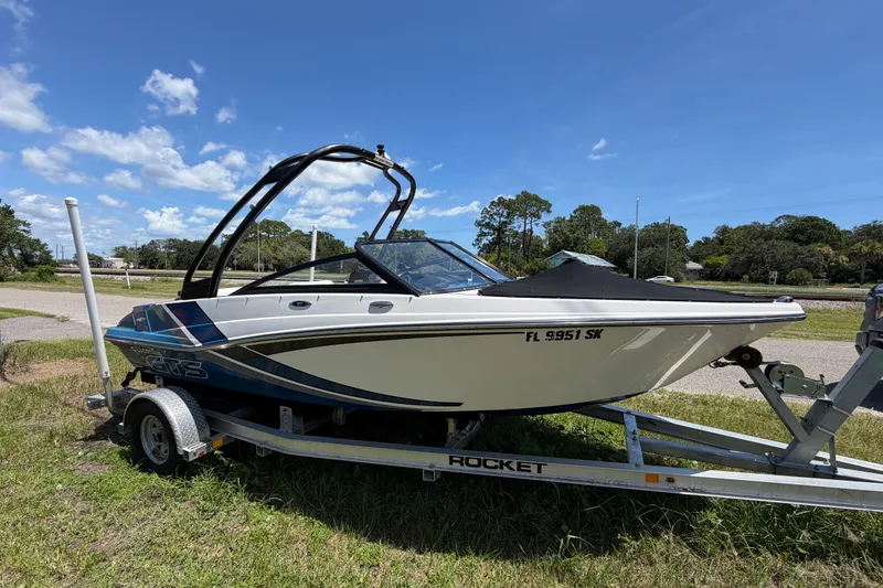 The Image of 2018 Glastron GTS 187 boat on trailer under clear blue sky. - 0