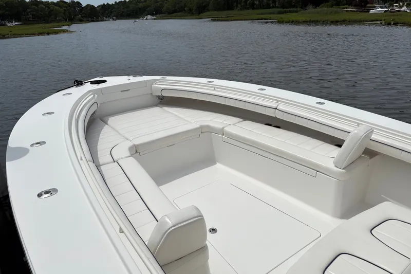 Slide: The Image of 2016 Regulator 34 boat with spacious white seating on a calm waterway. - 10