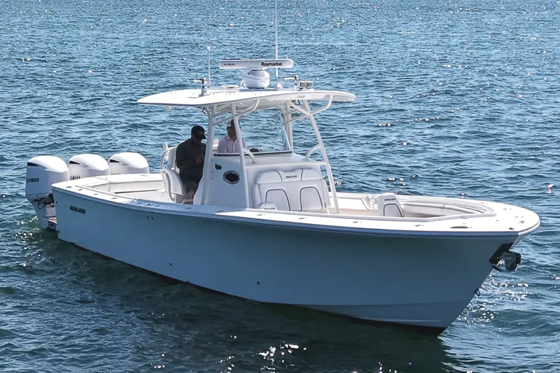 Slide: The Image of 2016 Regulator 34 on calm water with three outboard engines and a spacious deck. - 7