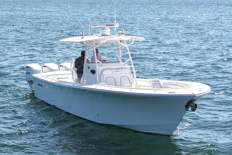 Slide: The Image of A 2016 Regulator 34 boat on calm water with three outboard engines. - 6