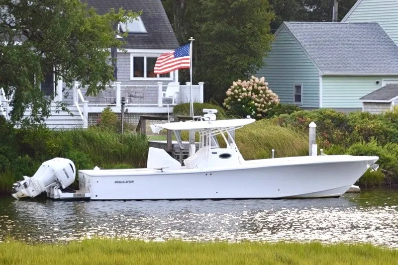 Slide: The Image of 2016 Regulator 34 boat docked by a house with an American flag. - 8