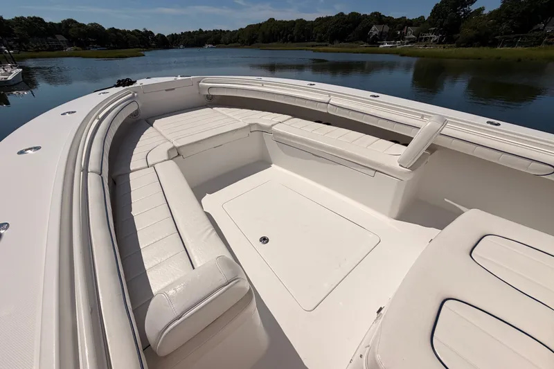 Slide: The Image of 2016 Regulator 34 boat with spacious seating, docked on a serene lake. - 19