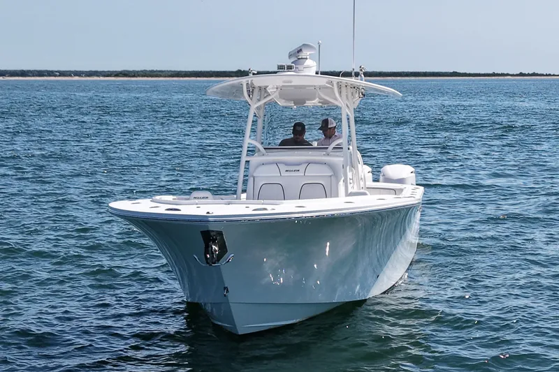 Slide: The Image of A 2016 Regulator 34 boat on calm water with two people on board. - 2