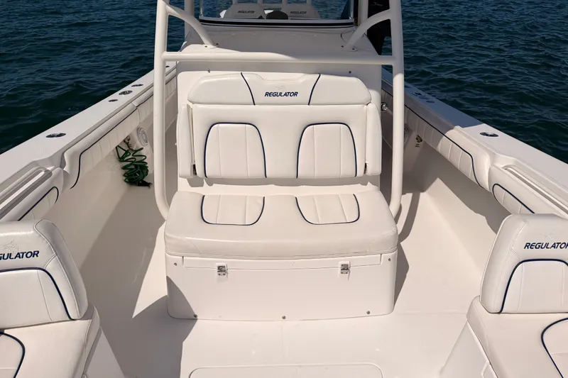 Slide: The Image of 2016 Regulator 34 boat interior with white seating and ocean backdrop. - 27