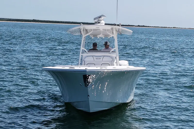 Slide: The Image of A 2016 Regulator 34 boat on calm water with two people on board. - 3