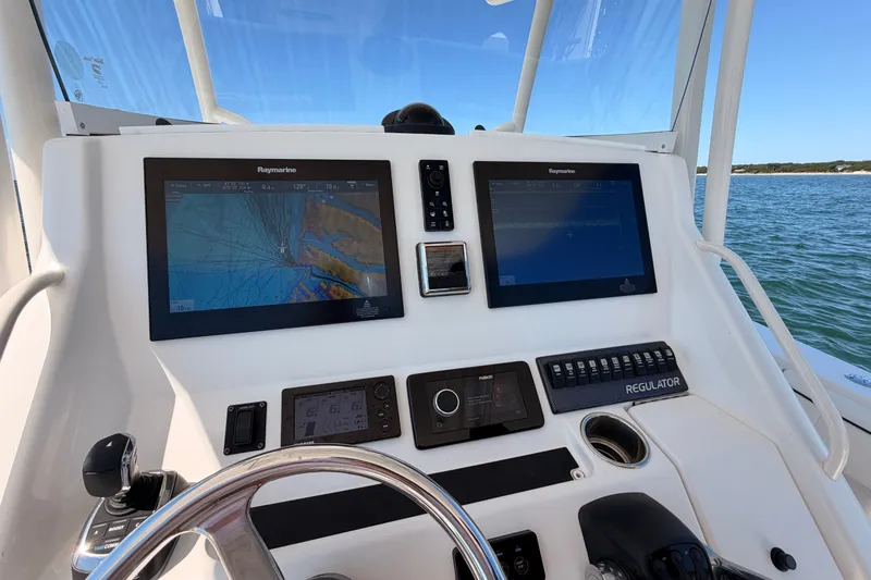 Slide: The Image of Helm of 2016 Regulator 34 boat with Raymarine navigation displays on open water. - 25