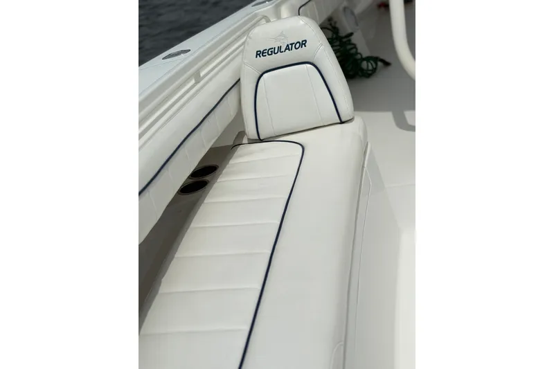 Slide: The Image of 2016 Regulator 34 boat with white cushioned seating and logo detail. - 14