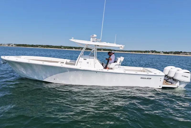 The Image of A white motorboat cruising on calm water, with a man on board. - 0